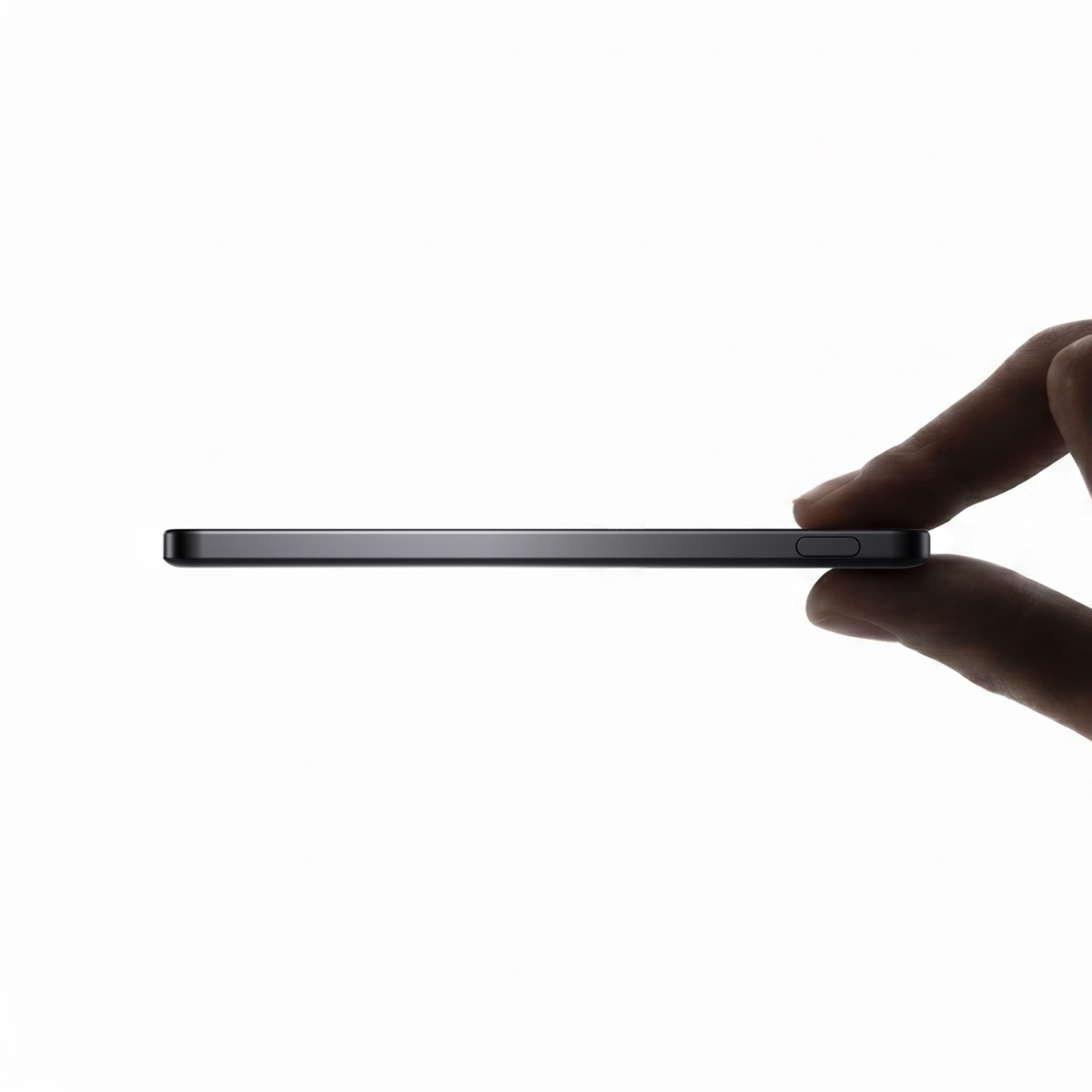 A clean side profile of the Reetle hub in Slate Black, finger resting on the side button, photographed against a white studio backdrop.